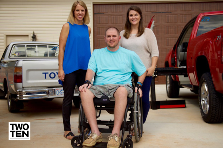 Two women and a man in a wheelchair with Two Ten Foot Foundation logo
